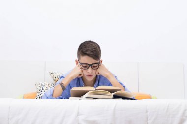 Yatak eğitim kitapları ile genç çocuk