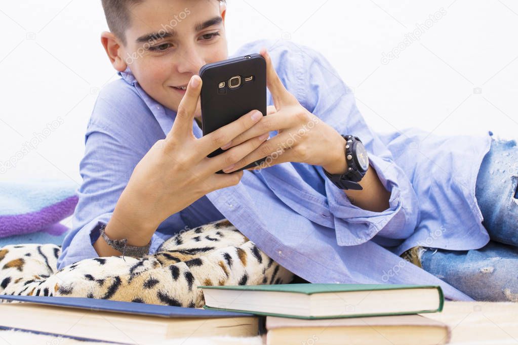 child with a mobile phone lying at home