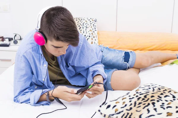 teenage boy with mobile phone and headphones listening to music