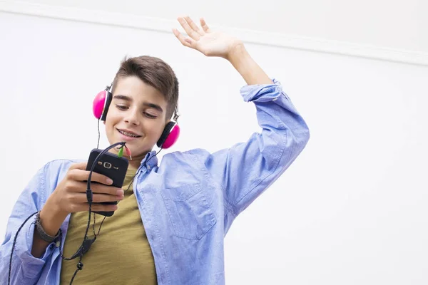 携帯電話とヘッドフォンの音楽を聴くと 代の少年 — ストック写真