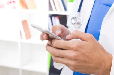 Doktorun elinde cep telefonu ile tıp