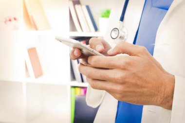 Doktorun elinde cep telefonu ile tıp