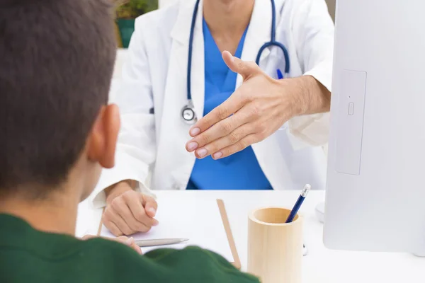 doctor in consultation greeting patient