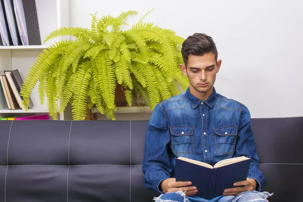 Jongeman Lezen Bank Van Het Appartement — Stockfoto