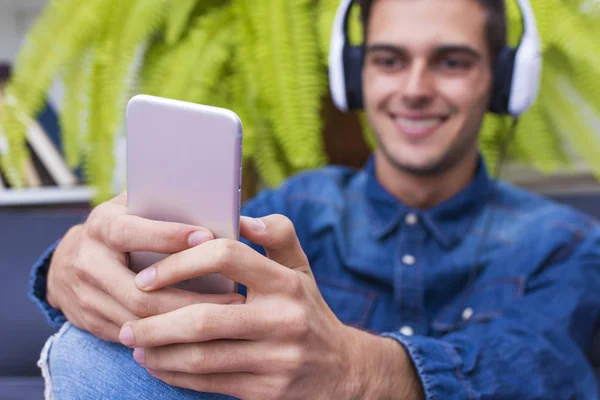 Junger Mann Hört Mit Telefon Und Kopfhörer Musik Wohnzimmer — Stockfoto