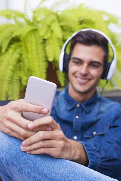 Joven Escuchando Música Hogar Salón Con Teléfono Auriculares —  Fotos de Stock