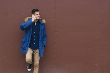 genç adam açık cep telefonu duvar üzerinde