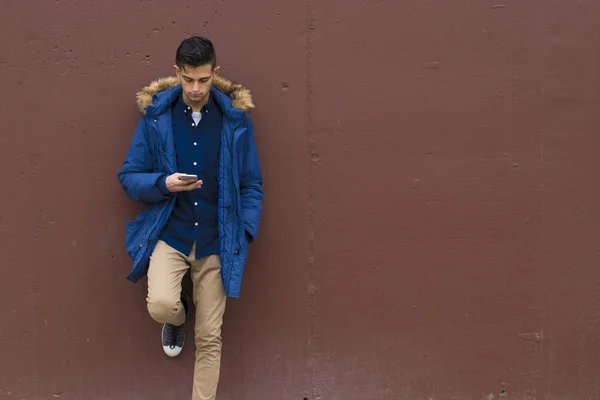 young man on the wall with outdoor mobile phone