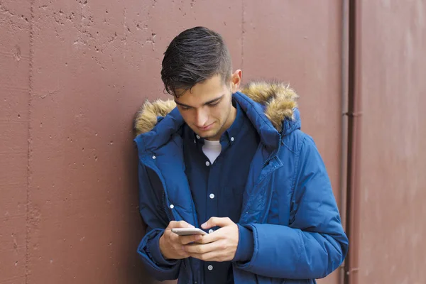 Junge Mit Handy Auf Stadtstraße Mit Hintergrundmauer — Stockfoto