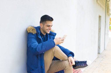 Genç duvar sokak şehrin üstünde hareket eden telefon ile