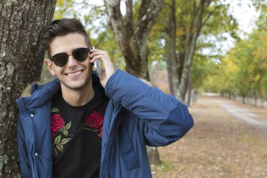 genç ile sonbaharda açık havada hareket eden telefon