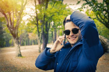 Genç üzerinde cep telefonu açık havada konuşurken Güz