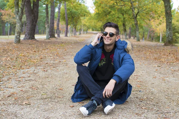 Joven Sentado Aire Libre Con Teléfono Móvil —  Fotos de Stock