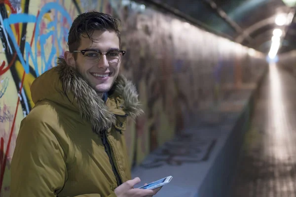 young with mobile phone in the underground of the city