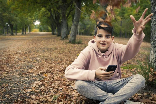 秋天的公园里有手机的年轻少年 — 图库照片