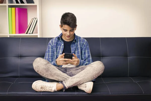 青少年或青春期坐在沙发上的手机 — 图库照片