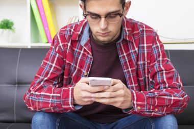 hareket eden telefon içinde ev veya apartman kanepe ile genç yetişkin