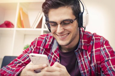 hareket eden telefon ve kulaklık ile genç gülümseyen portresi