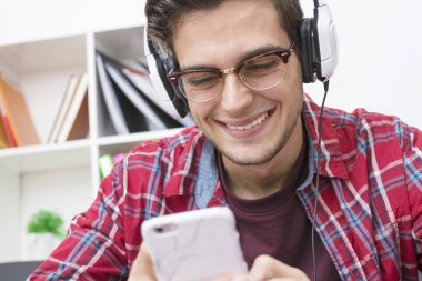 hareket eden telefon ve kulaklık ile genç gülümseyen portresi