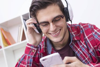 hareket eden telefon ve kulaklık ile genç gülümseyen portresi