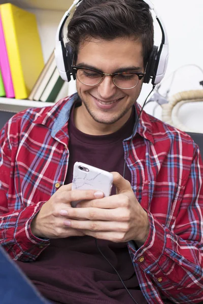 Ung Vuxen Eller Tonåring Med Mobiltelefon Och Hörlurar Hemma — Stockfoto