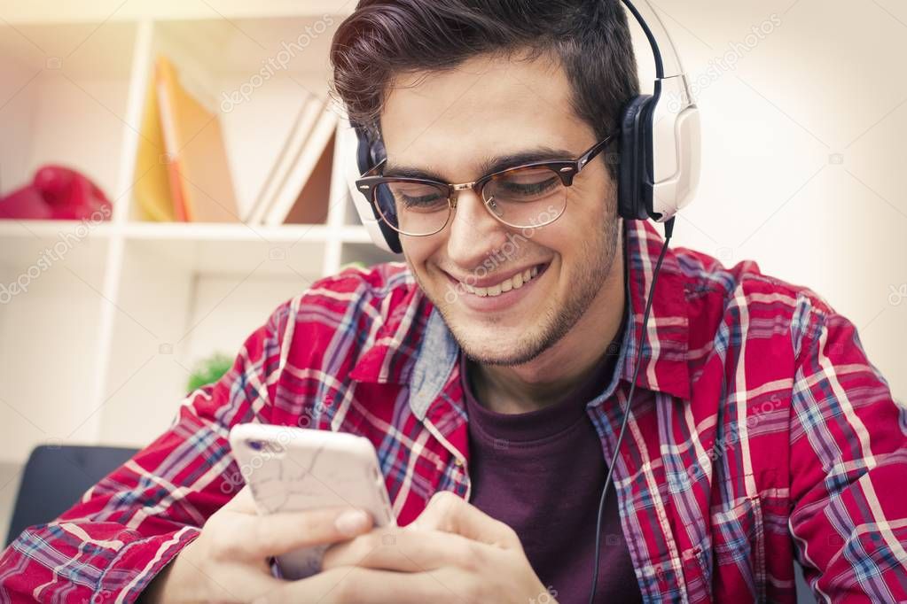 portrait of young smiling with mobile phone and earphones
