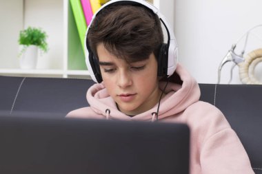 bilgisayar ve evde kulaklık ile genç