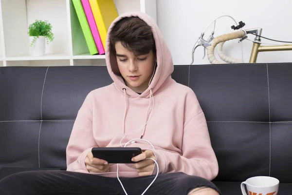 teenager or preteen with mobile phone on the sofa at home