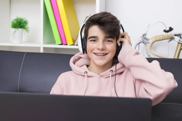 young with computer and headphones at home