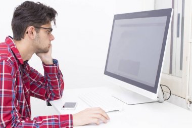 Evde bilgisayarı olan genç bir adam.