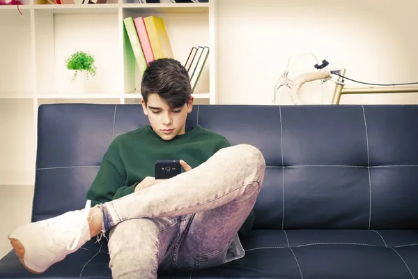 teenager with mobile phone on the sofa at home