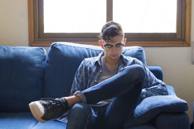 genç adam cep telefonu ile ev kanepe