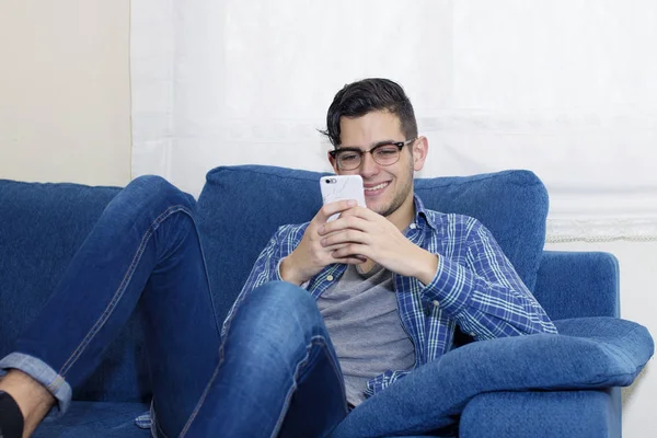 Jeune Homme Avec Téléphone Portable Sur Canapé Dans Appartement — Photo