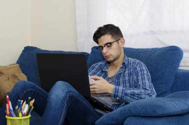 cep telefonu ve laptop ile ev kanepe genç