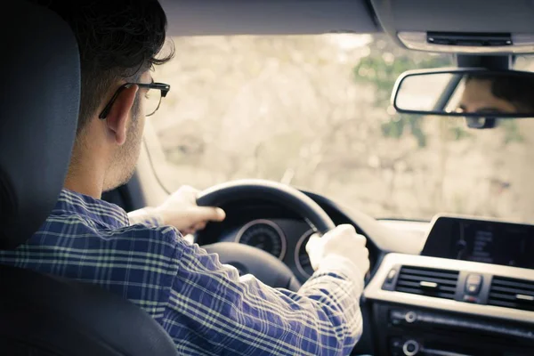 young man driving behind the wheel of the car