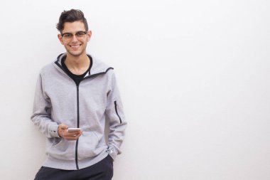 Beyaz arka plan üstünde hareket eden telefon ile genç rahat tarzı