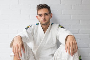 Dövüş sanatları üniformalı genç bir sporcu.