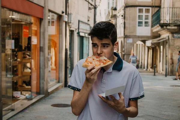 Νεαρός Άνδρας Τρώει Πίτσα Στο Δρόμο Της Πόλης — Φωτογραφία Αρχείου