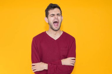 Genç adam uykusunda esniyor. Renkli arka planda.