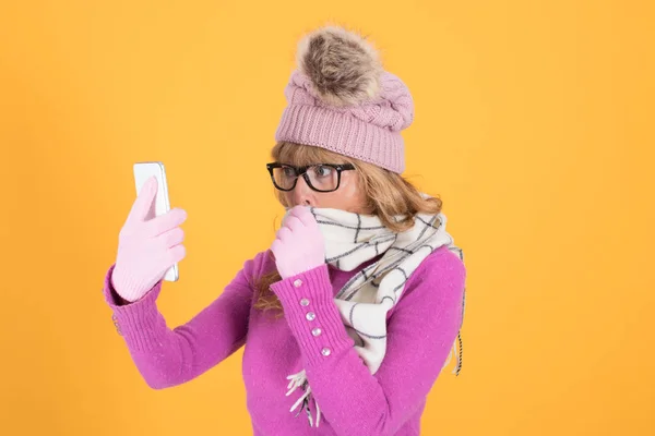 冬天拿着彩色背景手机的女人 — 图库照片