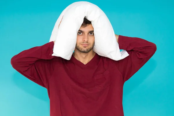 young man with pillow isolated on color background