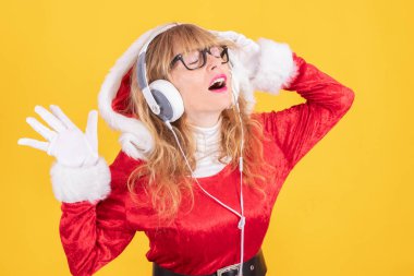 Noel Baba kostümlü kadın ve kulaklıklı kadın renk arka planında izole edilmiş.