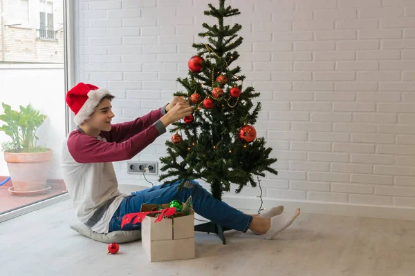 Young Teenage Man Home Decorating Christmas Tree — ストック写真