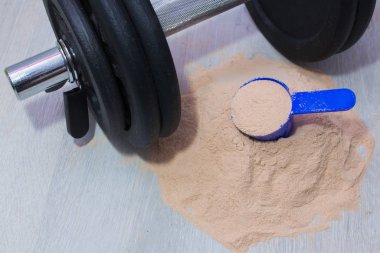 Spor salonunda protein tozu ve dambıl.