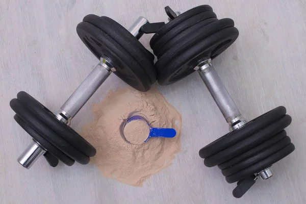 protein powder and dumbbell in the gym