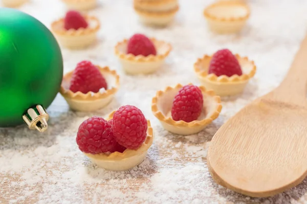 natural raspberry cakes or candies with christmas ornaments