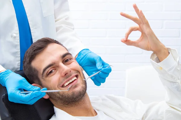 牙医的病人带着信号微笑 — 图库照片