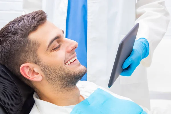 Pacjent Dentysty Uśmiechnięty Patrząc Urządzenie — Zdjęcie stockowe