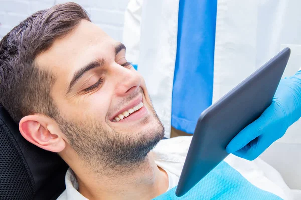 Paciente Dentista Sorrindo Olhando Para Dispositivo — Fotografia de Stock