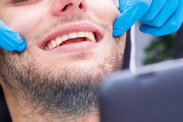 dentist with tools working on the patient\'s mouth